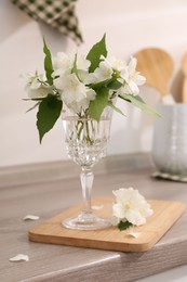 Beautiful jasmine flowers on wooden table indoors