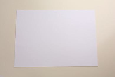 Sheet of parchment paper on beige background, top view