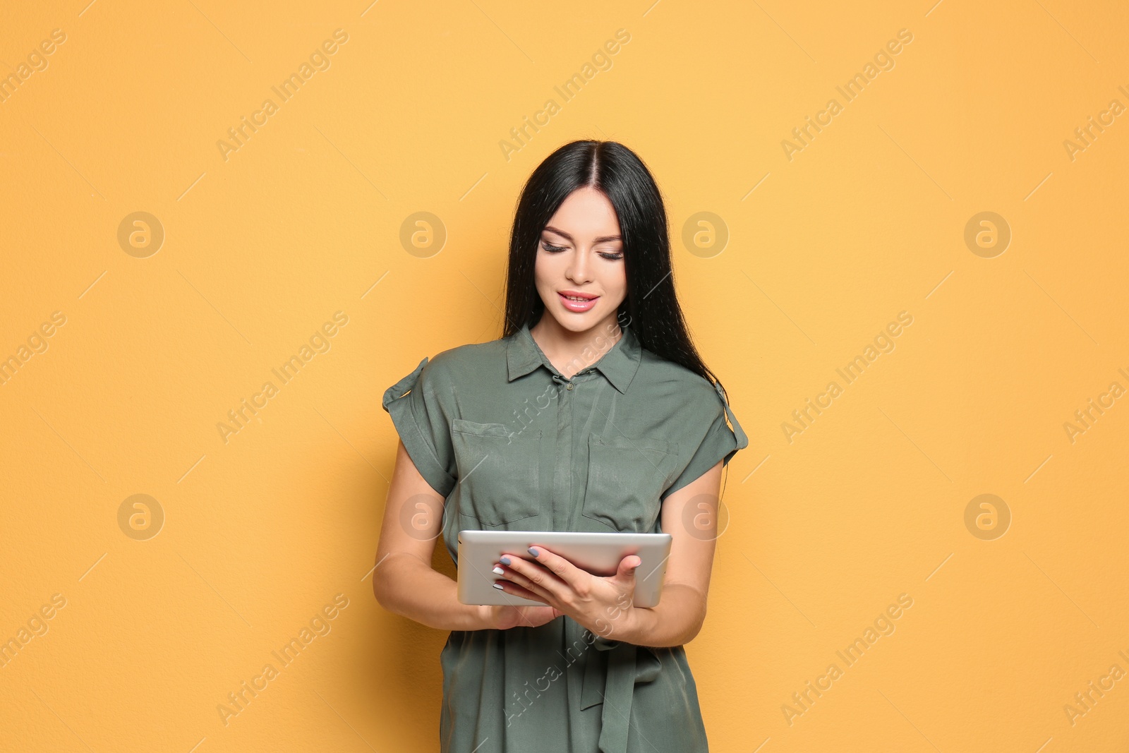 Photo of Beautiful woman with tablet on color background