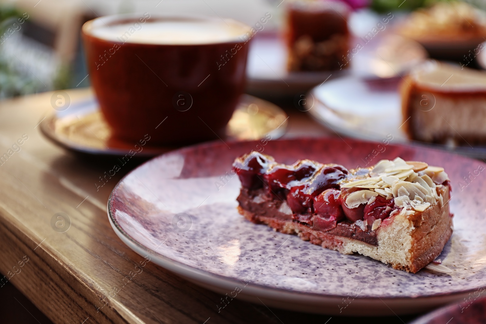 Photo of Plate with slice of cherry cake on wooden table