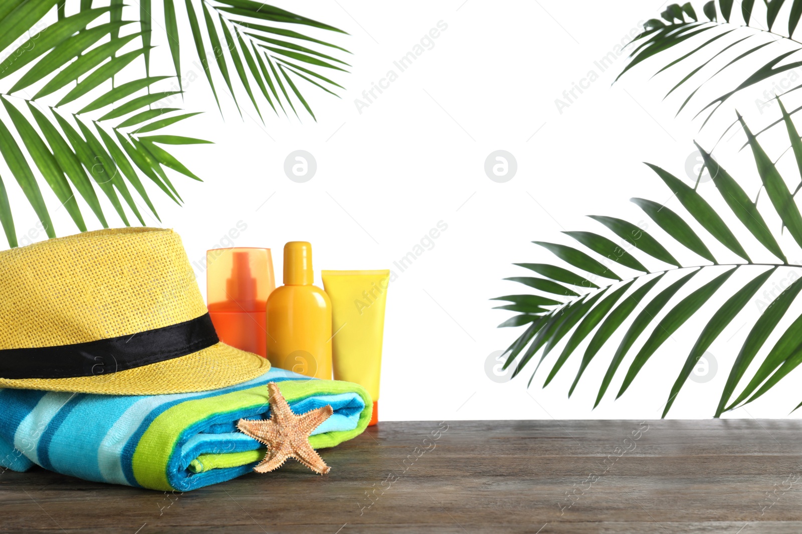 Photo of Different beach objects on wooden table against white background. Space for text