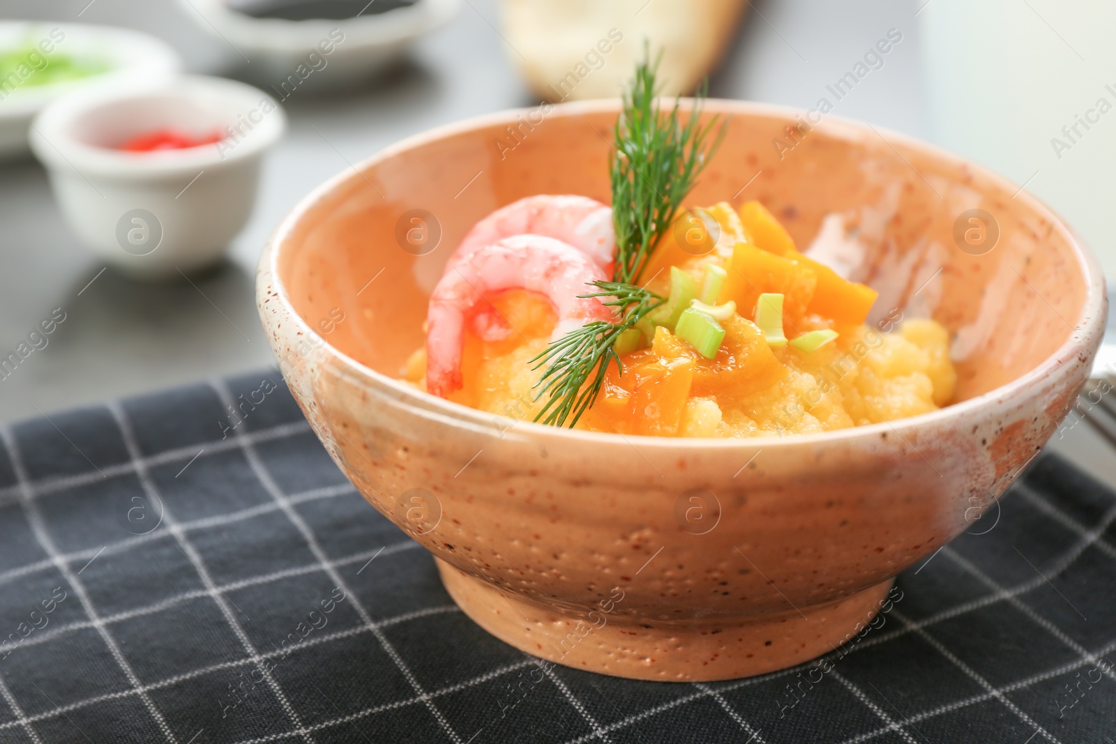 Photo of Bowl with fresh tasty shrimp and grits on table