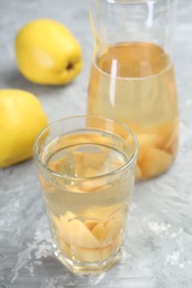 Photo of Delicious quince drink and fresh fruits on grey table, closeup