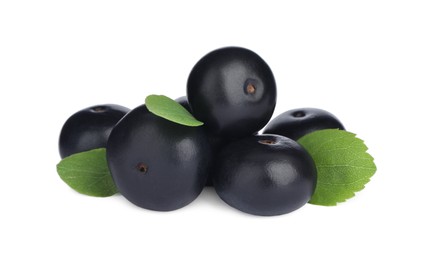 Pile of fresh ripe acai berries and green leaves on white background