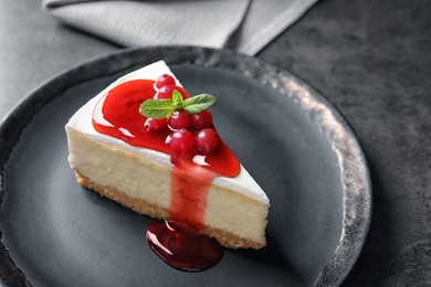 Photo of Delicious cheesecake served with sweet jam on plate