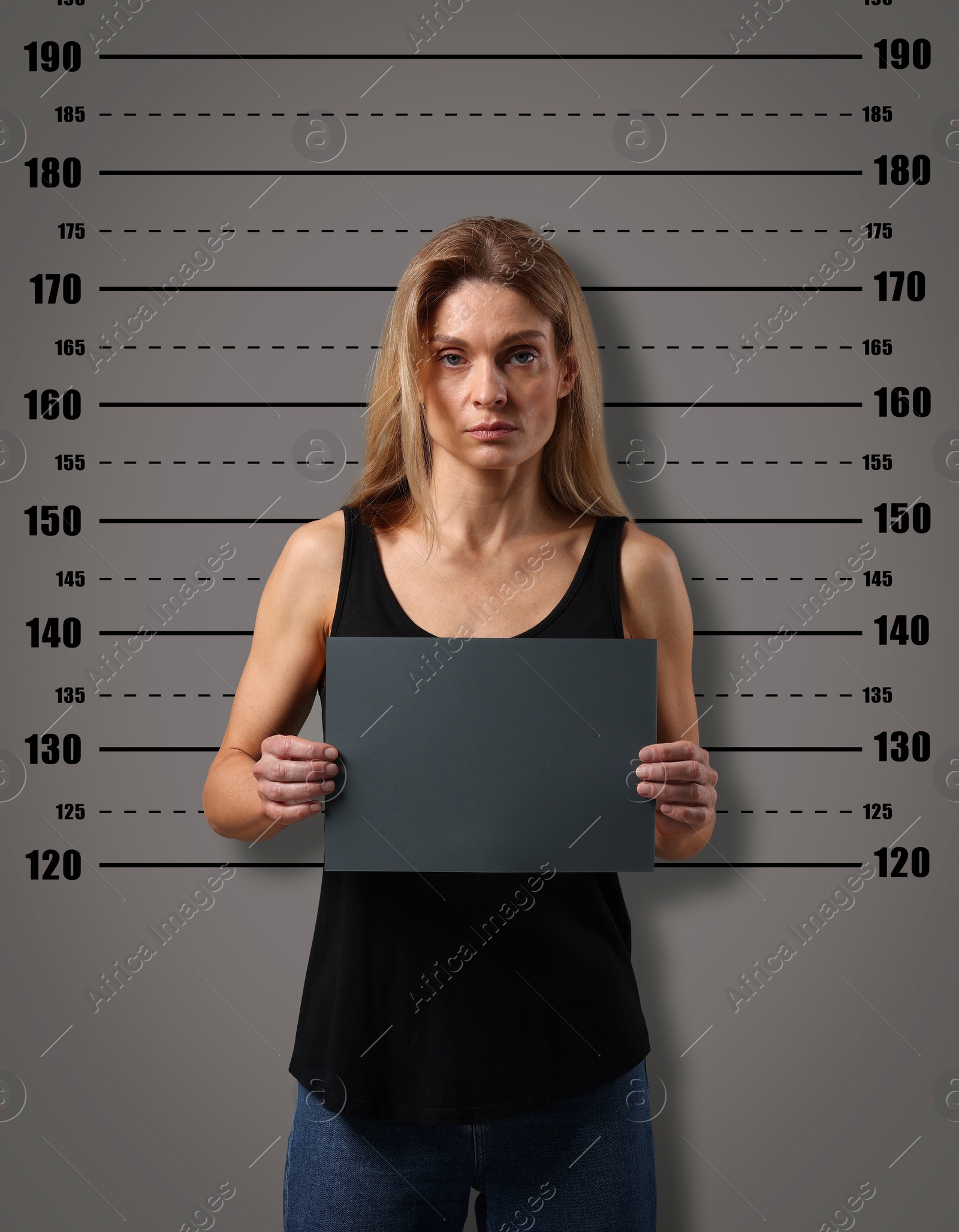 Image of Criminal mugshot. Arrested woman with blank card against height chart