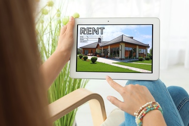 Image of Woman searching for house on rental property website via tablet computer, closeup