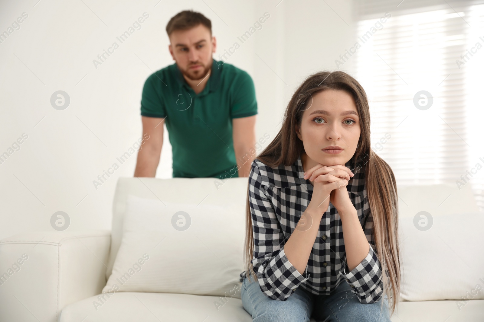 Photo of Unhappy young couple with relationship problems at home