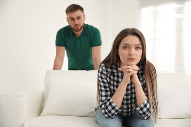 Photo of Unhappy young couple with relationship problems at home