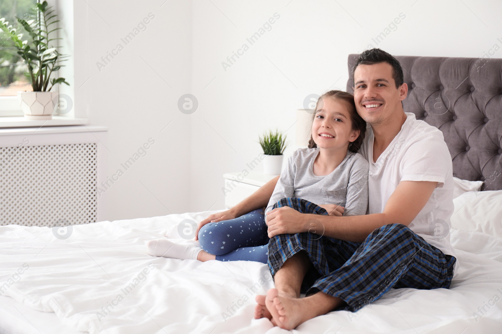 Photo of Father with his cute child in bedroom. Happy family