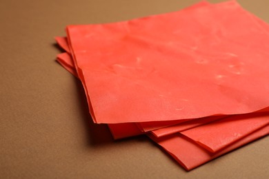 Red beeswax food wraps on brown background, closeup