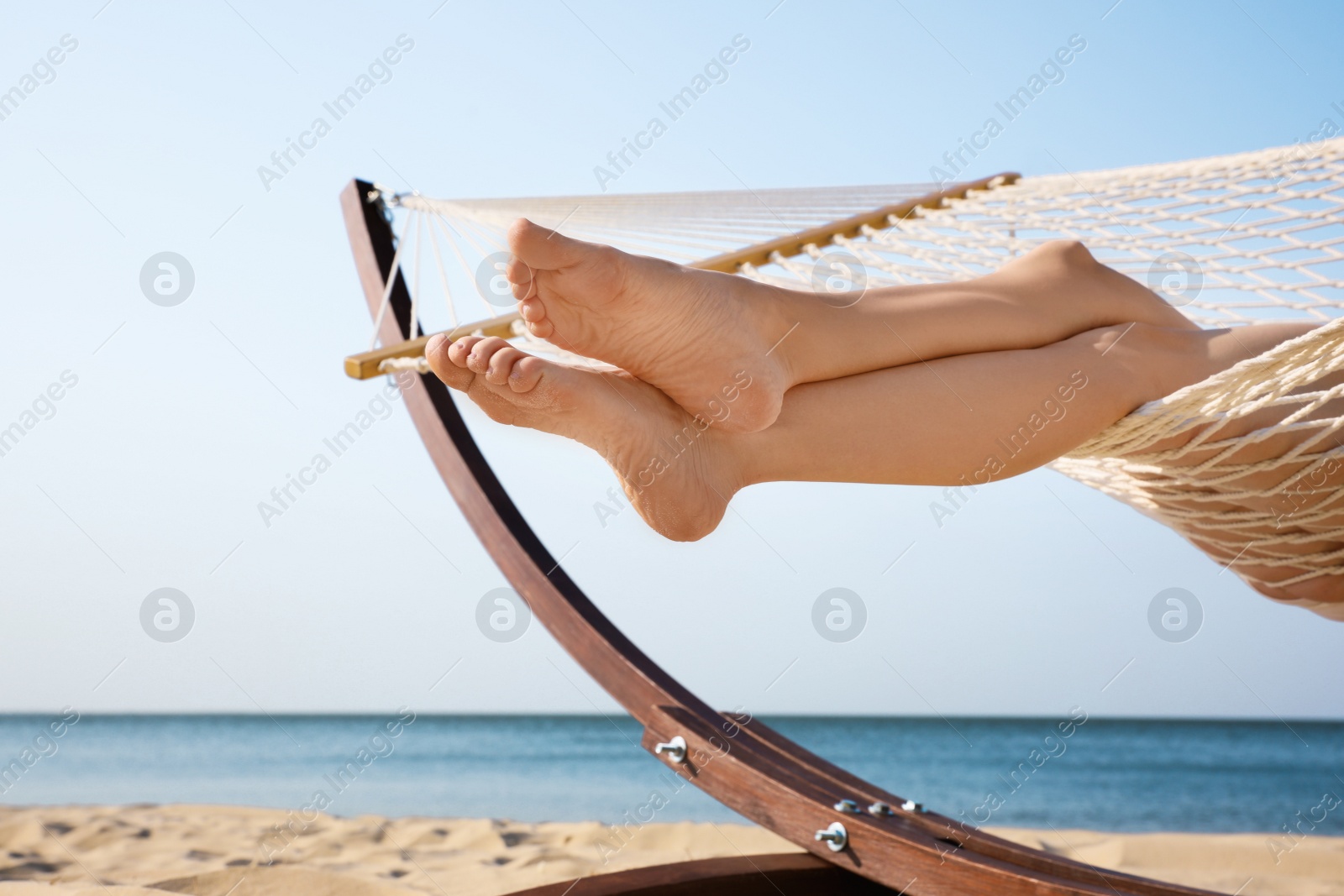 Photo of Young woman resting in hammock on beach, closeup