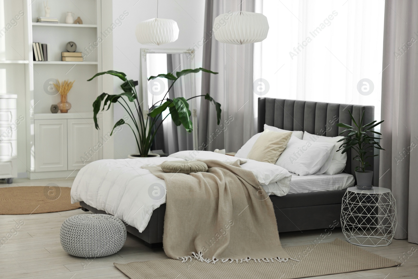 Photo of Soft beige plaid on bed in stylish bedroom. Interior design