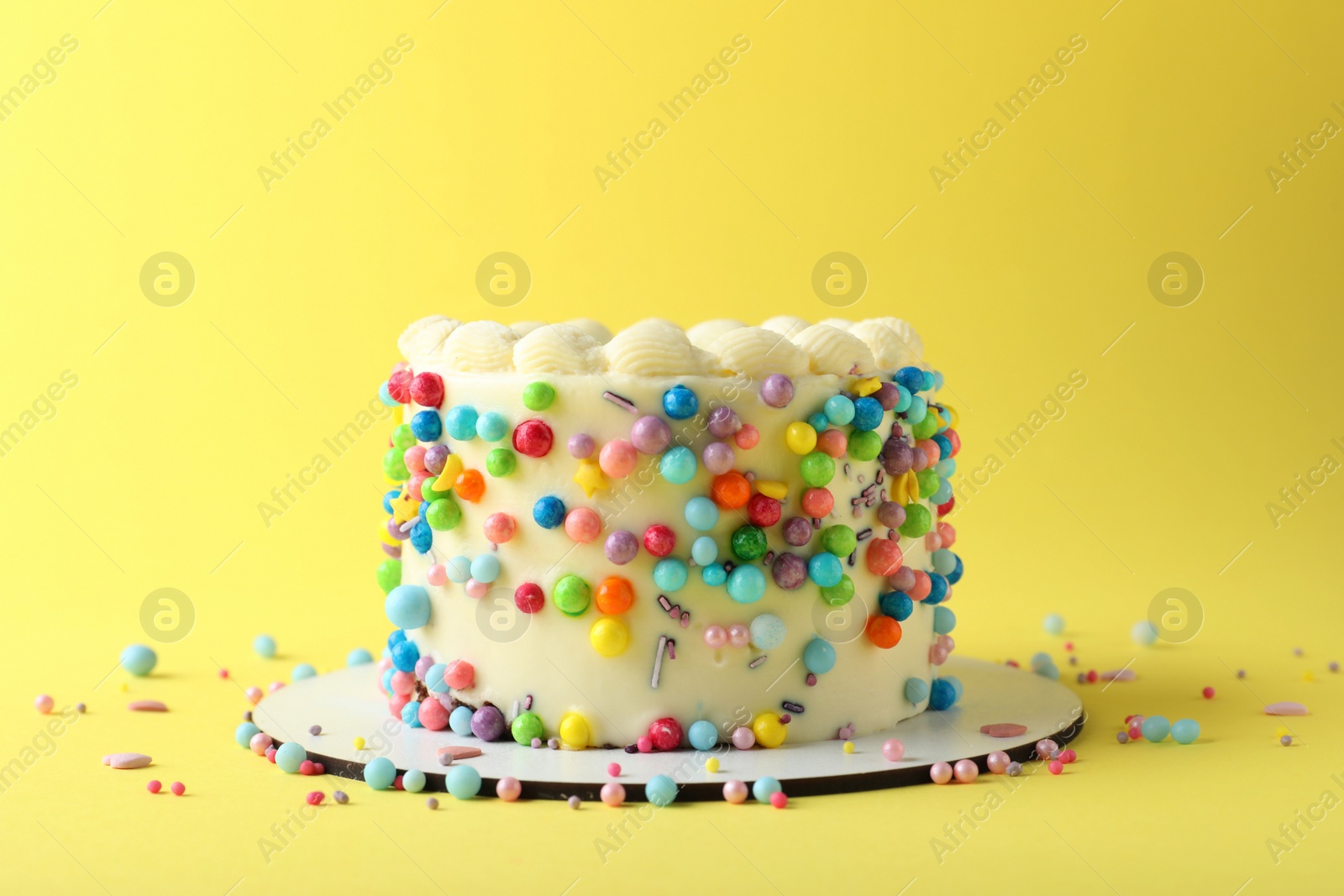 Photo of Cute bento cake with tasty cream on yellow background