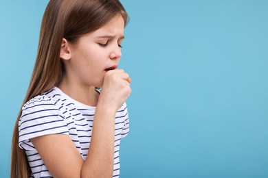 Photo of Sick girl coughing on light blue background, space for text