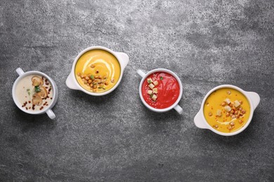 Photo of Different tasty cream soups on grey table, flat lay