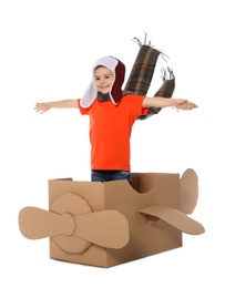 Photo of Cute little boy playing with cardboard airplane on white background