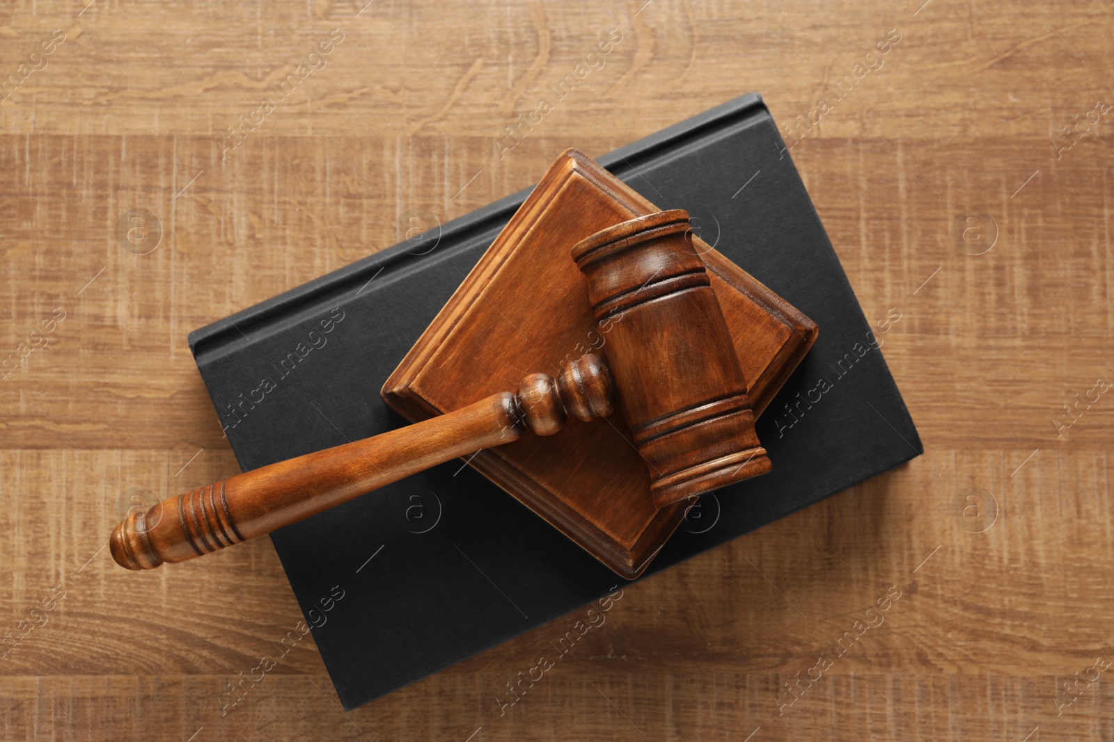 Photo of Law concept. Gavel and book on wooden table, top view