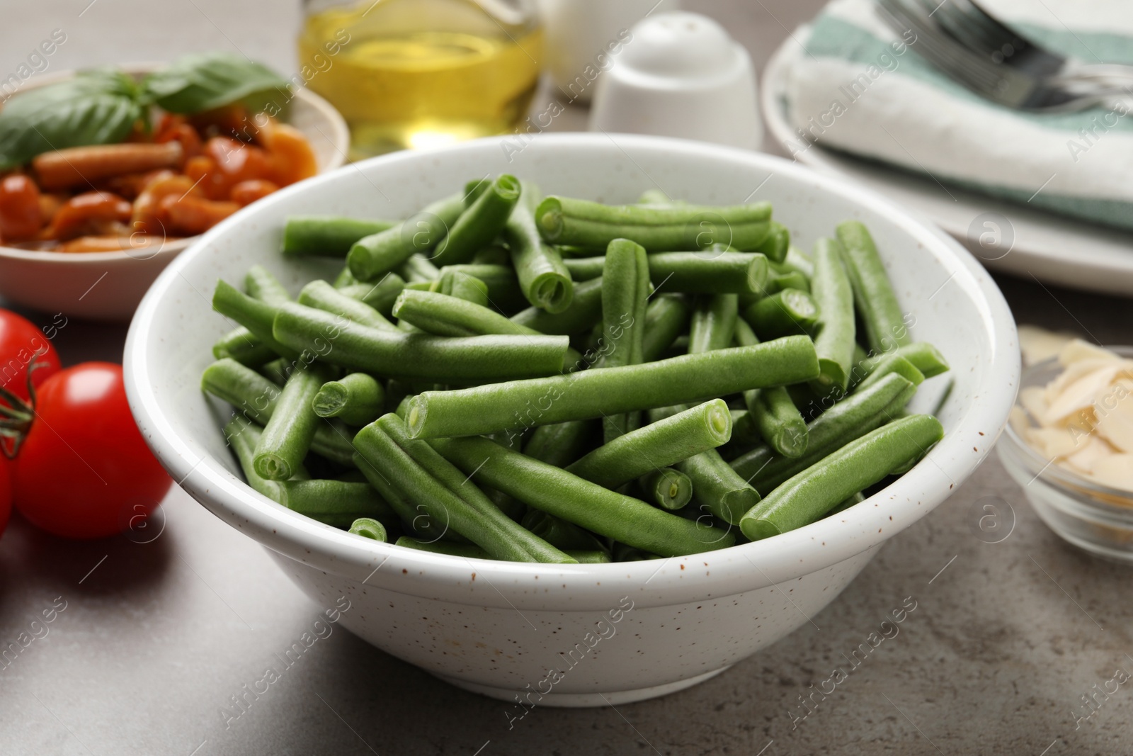 Photo of Fresh green beans and other ingredients for salad on grey table