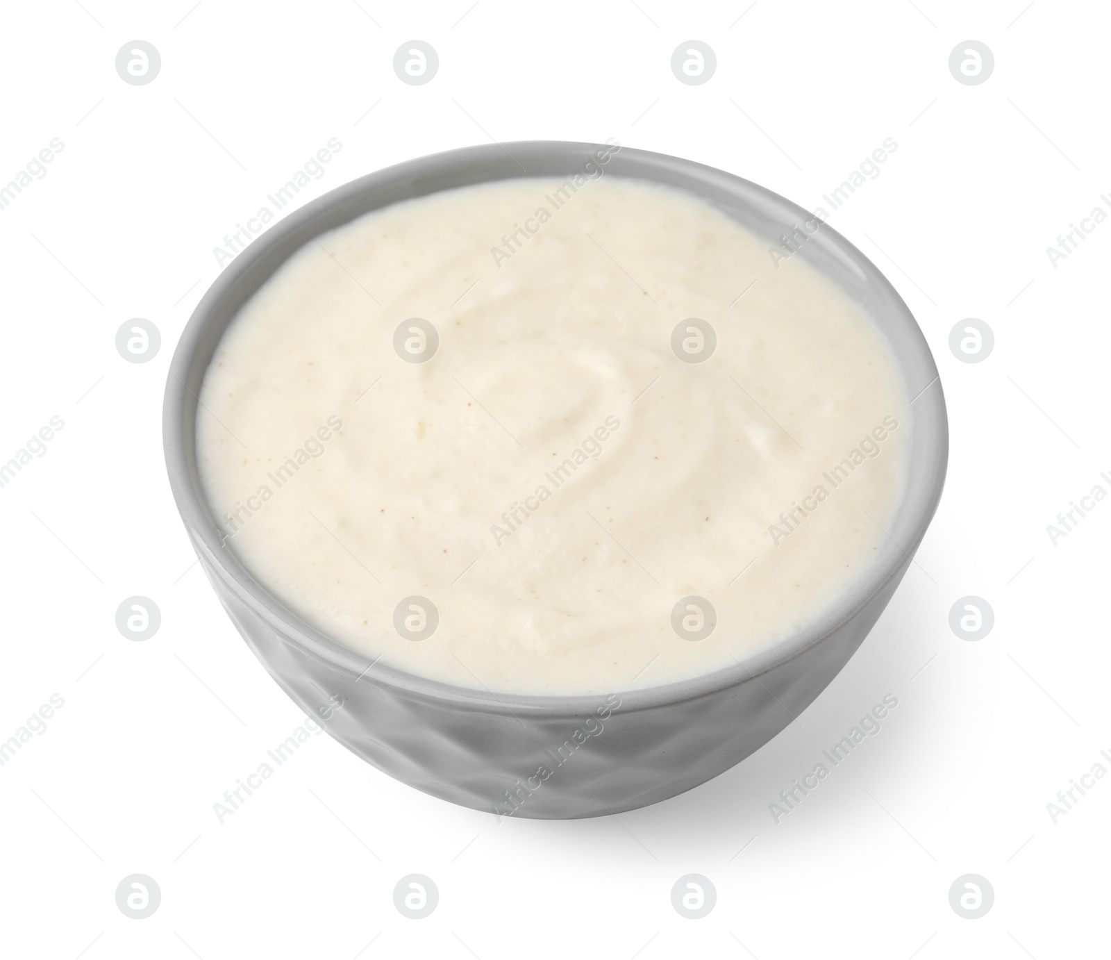 Photo of Delicious semolina pudding in bowl isolated on white