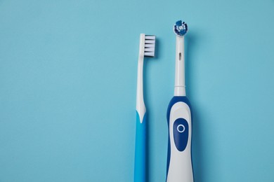 Photo of Electric and plastic toothbrushes on turquoise background, flat lay. Space for text