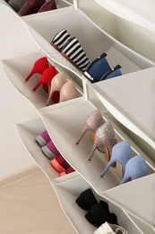 Photo of Shoe cabinet with footwear in room. Storage ideas