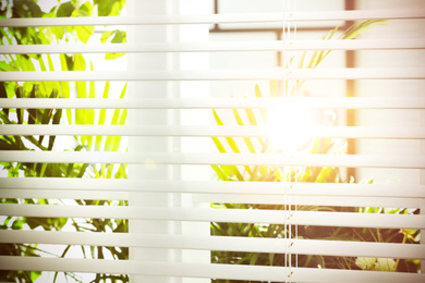 Image of Beautiful view through window with blinds on sunny day, closeup