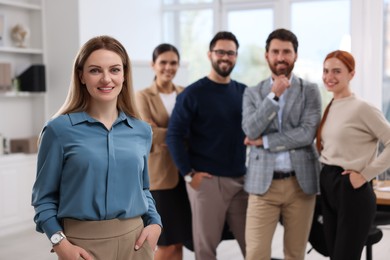 Photo of Portrait of happy businesswoman and her team in office