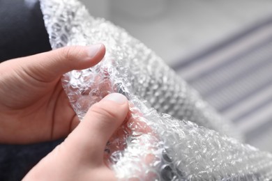 Photo of Boy popping bubble wrap, closeup. Stress relief