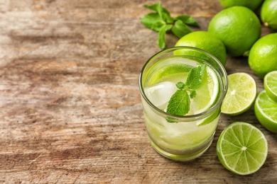 Photo of Refreshing lime beverage and ingredients on wooden background