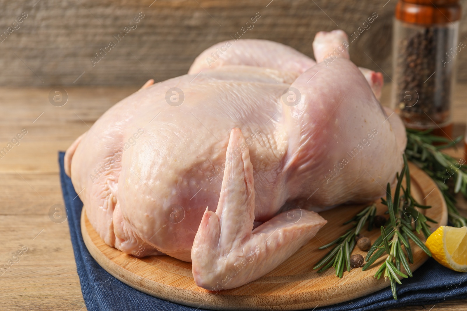 Photo of Fresh raw chicken with spices on wooden table, closeup