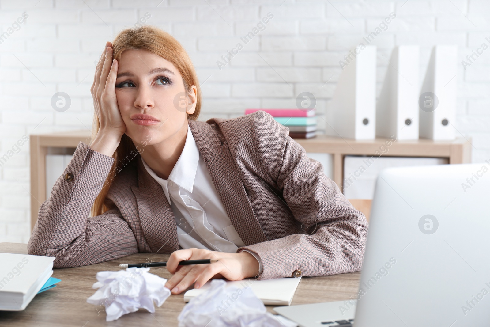 Photo of Lazy employee wasting time at table in office