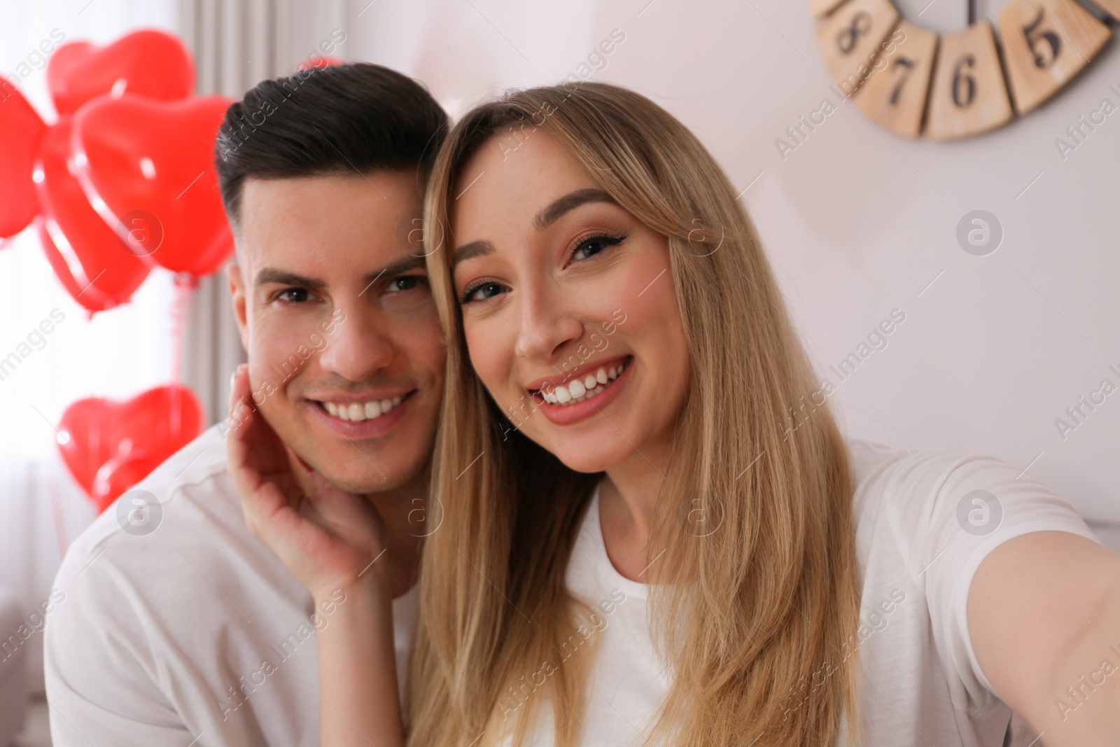 Photo of Lovely couple taking selfie at home. Valentine's day celebration