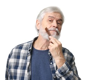 Photo of Senior man combing beard with comb on white background