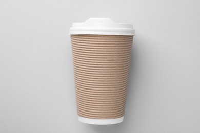 One paper cup on light grey background, top view. Coffee to go