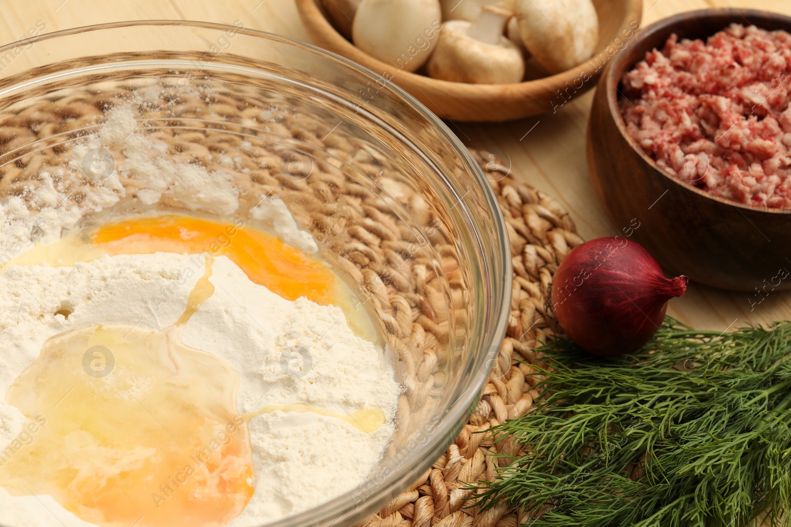 Photo of Bowl with flour, eggs and products on table, closeup