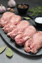Photo of Raw beef tongue pieces on grey table