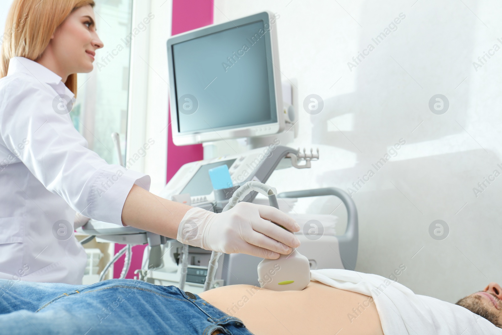 Photo of Doctor conducting ultrasound examination of internal organs in clinic