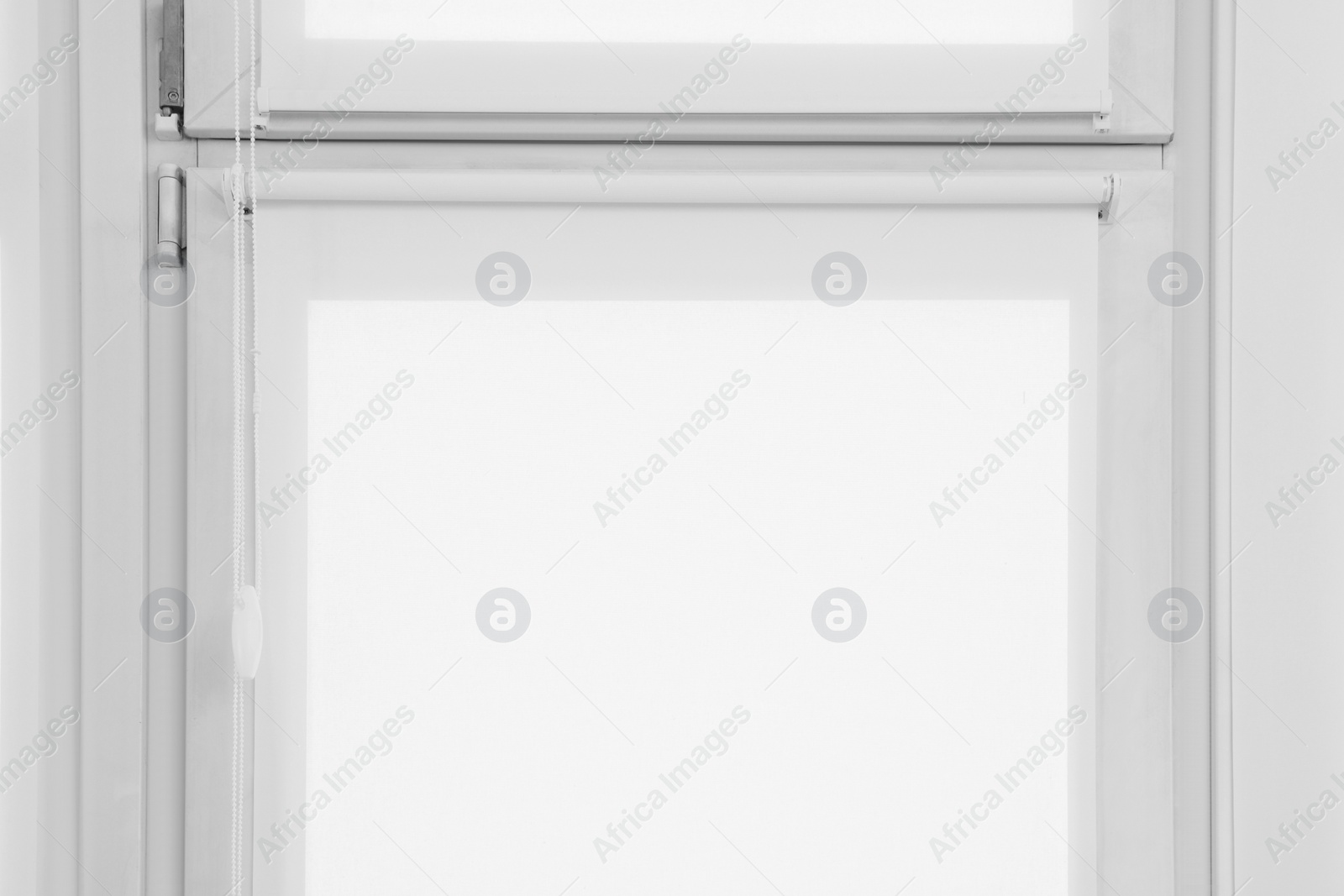 Photo of Window with closed white roller blinds indoors