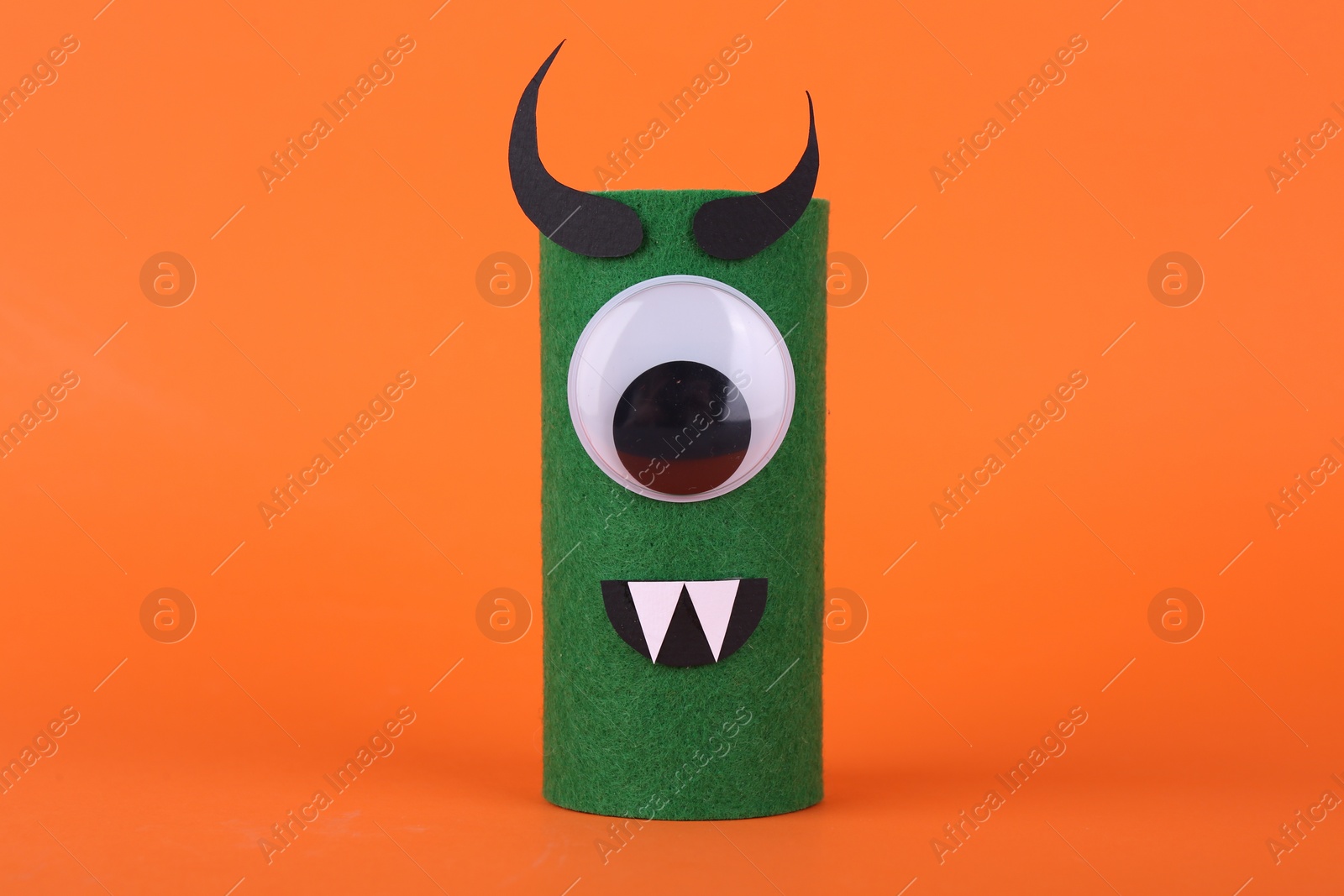 Photo of Spooky monster on orange background. Handmade Halloween decoration