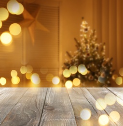 Image of Empty wooden surface and blurred view of room decorated for Christmas, space for text. Interior design