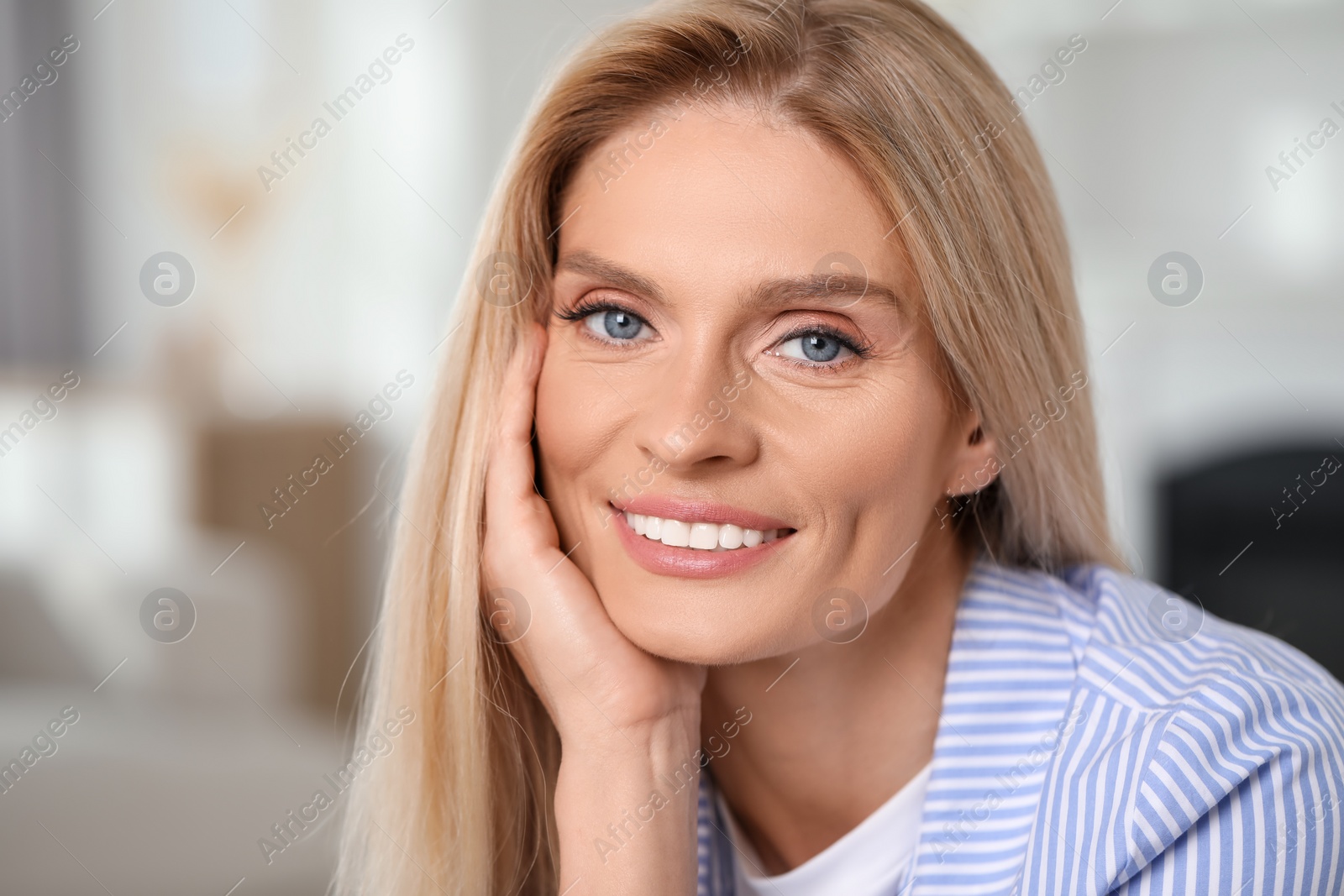 Photo of Portrait of smiling middle aged woman with blonde hair indoors