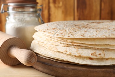 Many tasty homemade tortillas on wooden table, closeup