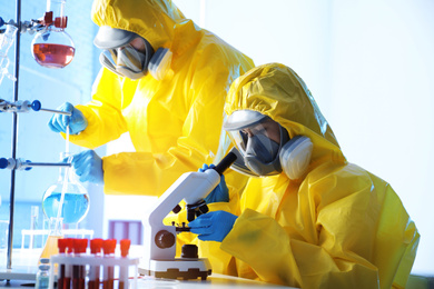 Photo of Scientists in chemical protective suits working at laboratory. Virus research