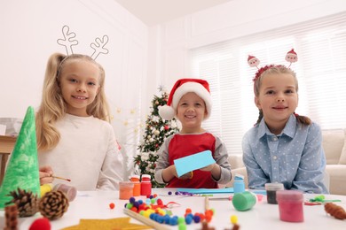 Photo of Cute little children making Christmas crafts at table in room