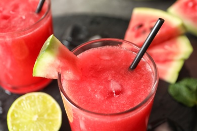 Photo of Tasty summer watermelon drink in glass on table, closeup