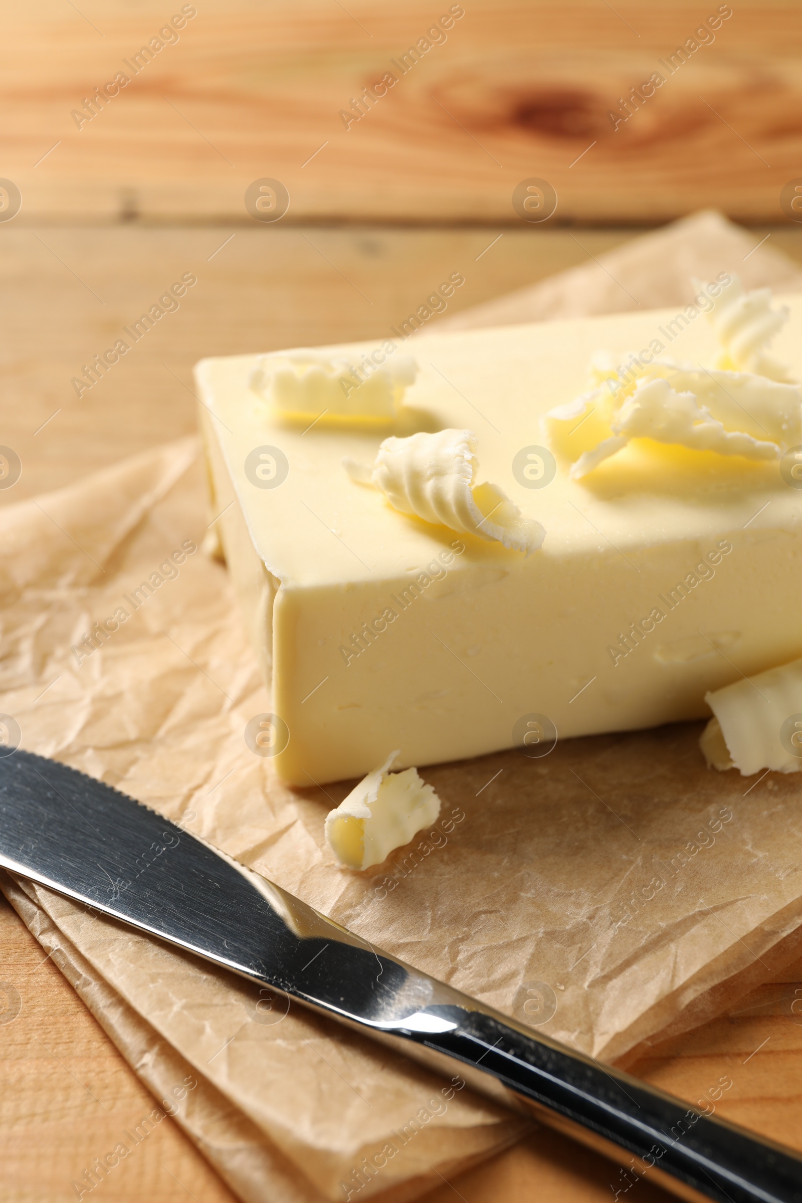 Photo of Tasty butter and knife on wooden table