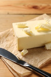 Tasty butter and knife on wooden table