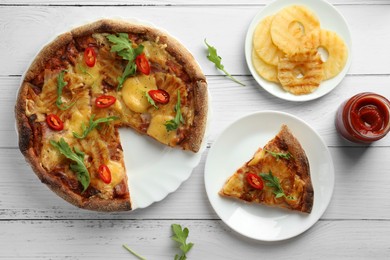 Photo of Delicious Hawaiian pizza with pineapple and ingredients on white wooden table, flat lay
