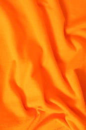 Texture of orange fabric as background, top view